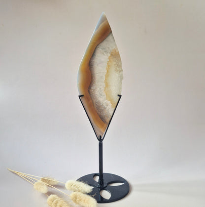 Unieke natuurlijke agaat sculptuur op zwarte metalen standaard met druzy kristallen en beige aardetinten.