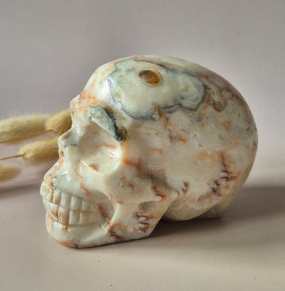 Grote handgeslepen Crazy Lace Agaat skull van circa 700 gram met natuurlijke crème en caramelkleurige patronen en glanzende afwerking.