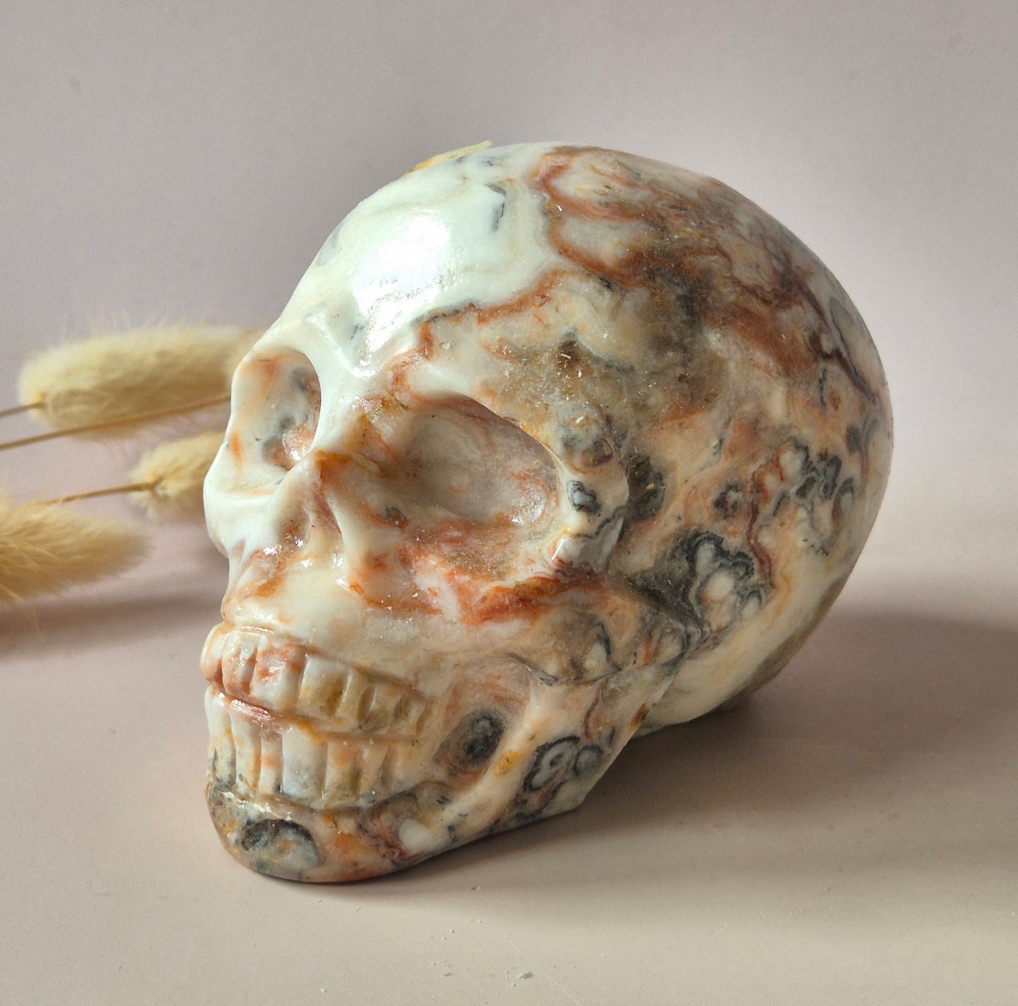 Grote handgeslepen Crazy Lace Agaat skull van circa 700 gram met natuurlijke crème en caramelkleurige patronen en glanzende afwerking.