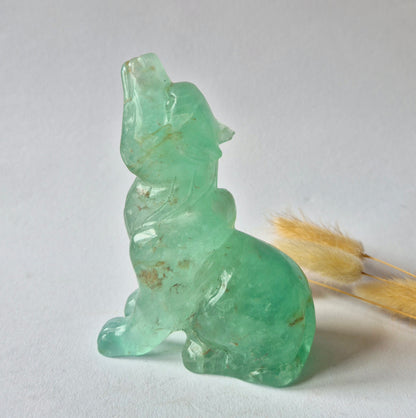 Handgesneden groene fluoriet wolf carving van 541 gram met transparante mintgroene kleur en natuurlijke insluitingen.